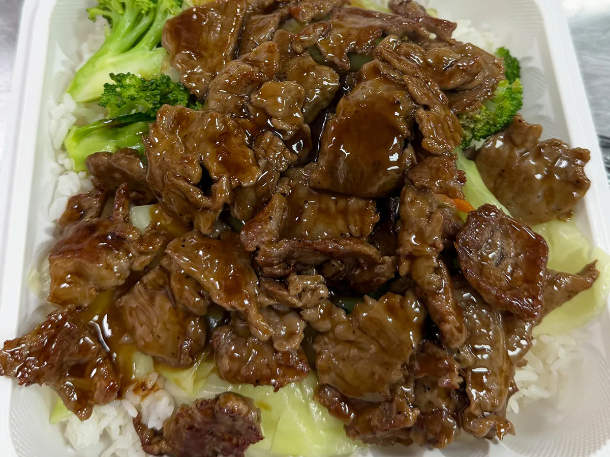 Beef with broccoli and white rice in a takeout container